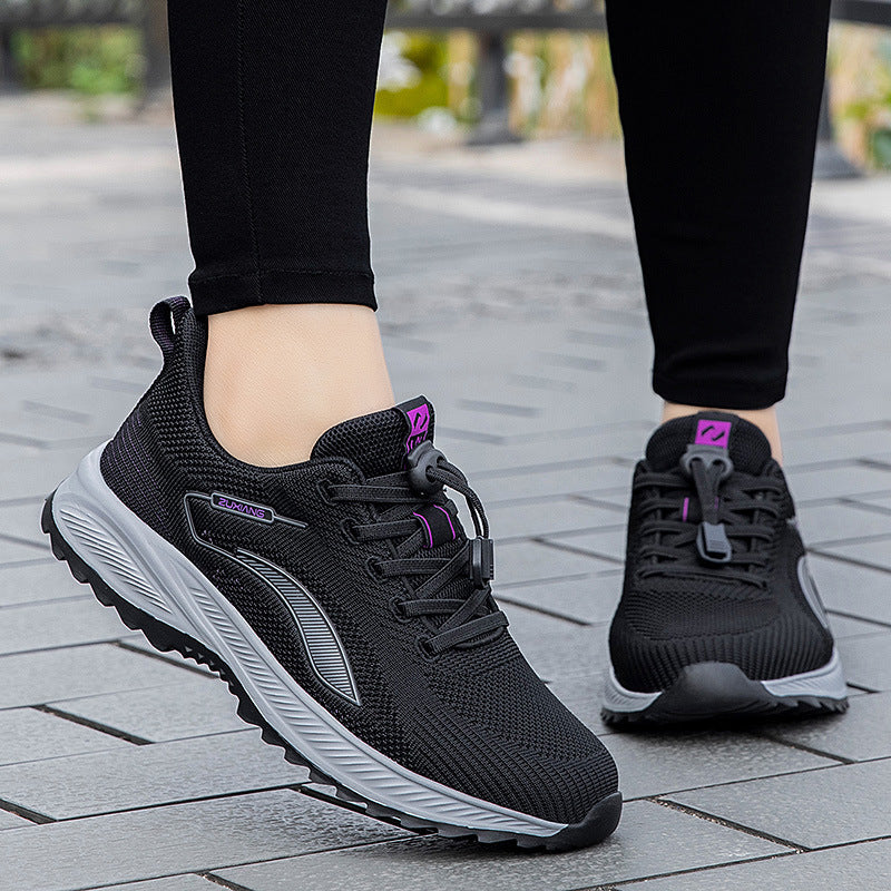 Anouk zwarte hardloopschoenen met paarse details, vooraanzicht op straattegels