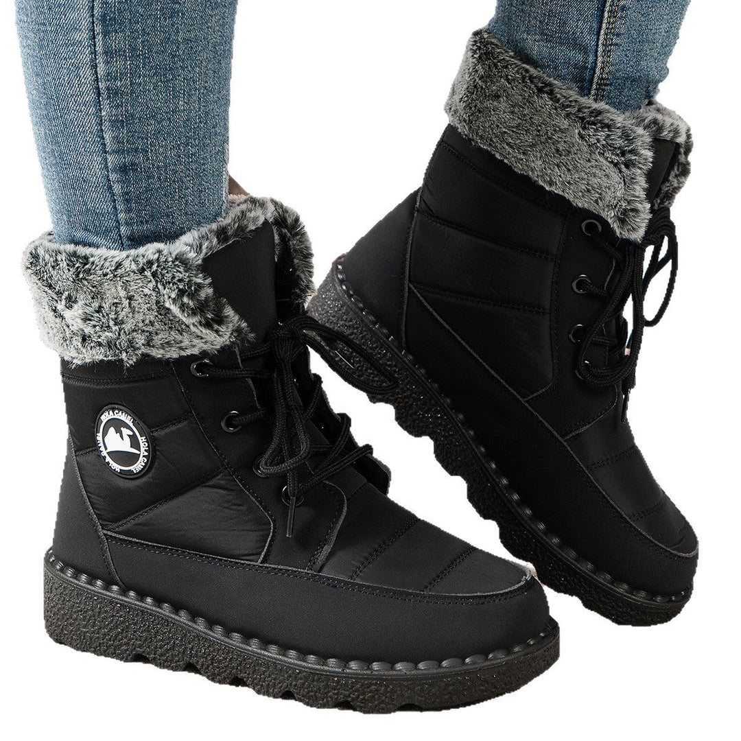Zwarte snowboots gedragen met spijkerbroek, close-up