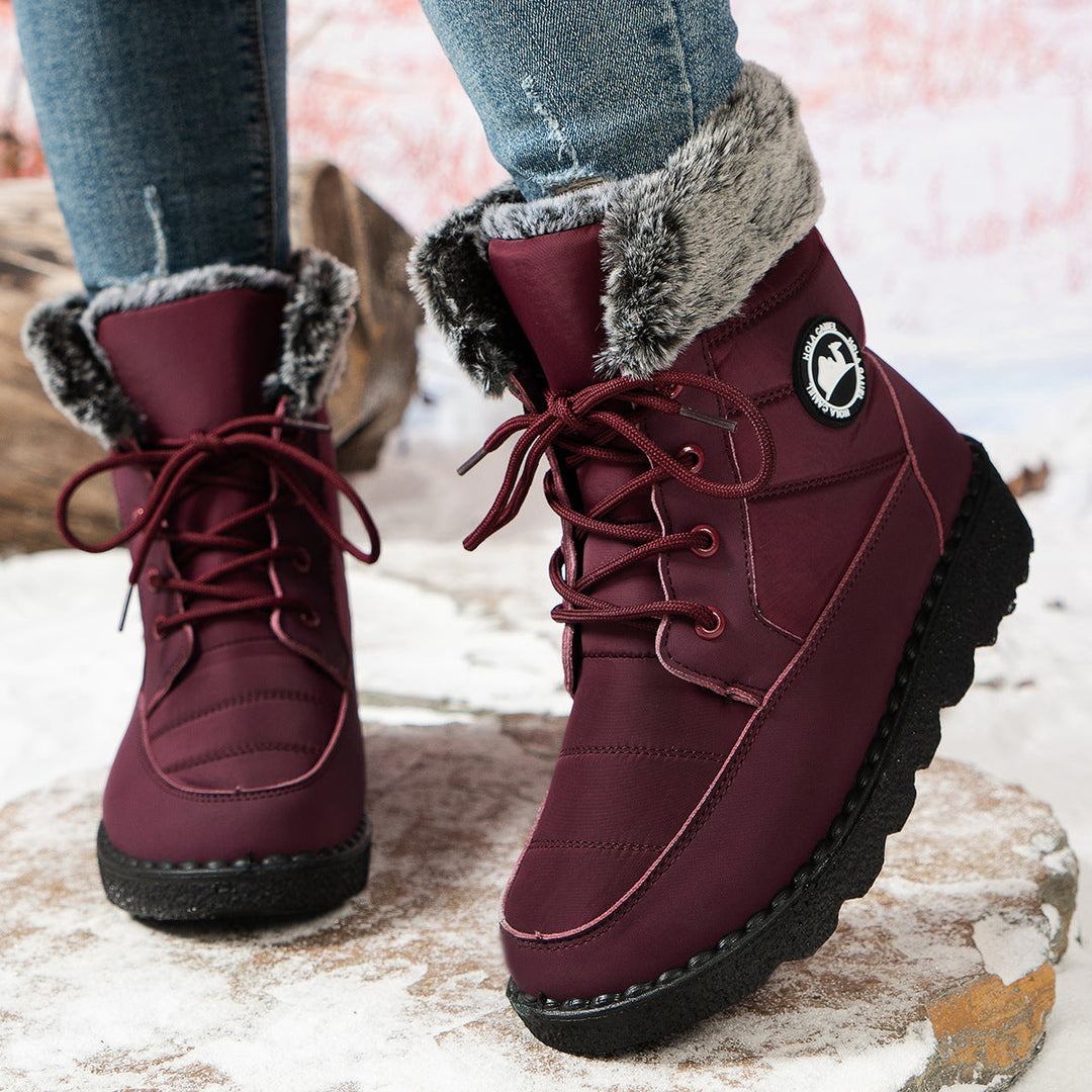 Bordeauxrode snowboots gedragen met spijkerbroek, close-up