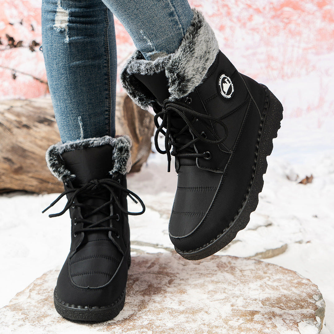 Zwarte snowboots in actie getoond, één laars opgetild