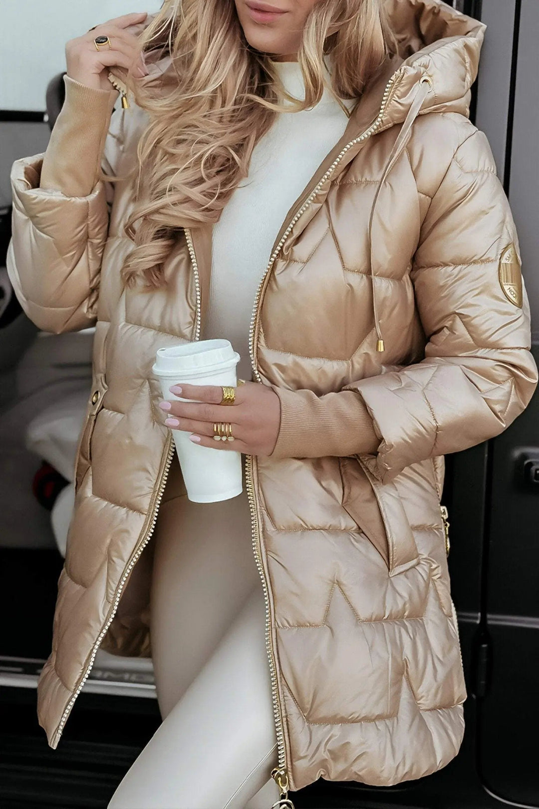 Loïs beige puffer jas met capuchon, close-up met koffie