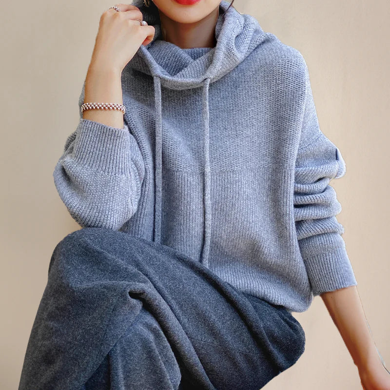 Merel grijs-blauwe trui met capuchon, zittende pose