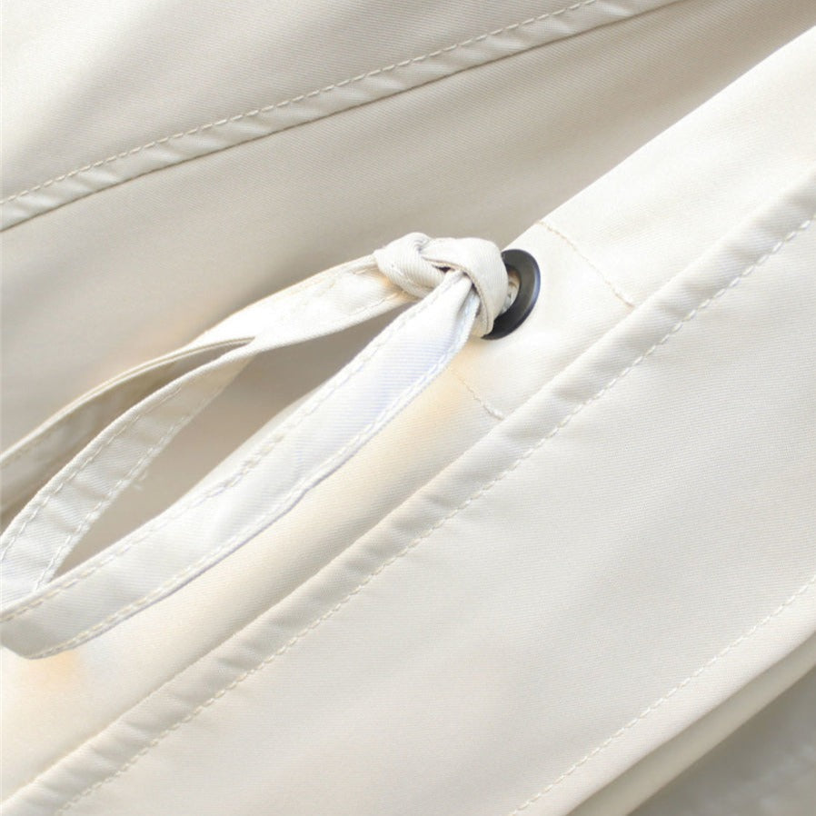 Detailfoto van de strikceintuur en knoopsluiting van de Merel trenchcoat