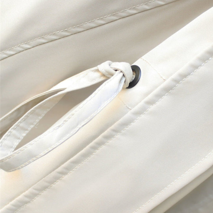 Detailfoto van de strikceintuur en knoopsluiting van de Merel trenchcoat