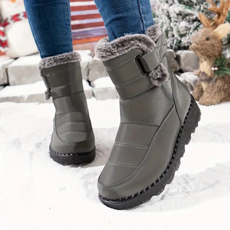 Sanne grijze gevoerde snowboots gedragen in de sneeuw, achteraanzicht