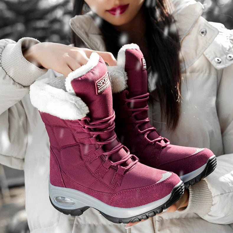Sanne gevoerde snowboots in bordeauxrode kleur vastgehouden door model