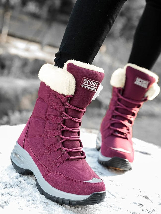 Close-up van bordeauxrode snowboots met witte bontkraag, zijaanzicht