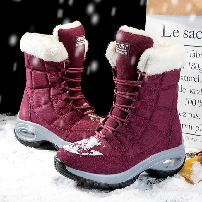 Bordeauxrode snowboots met bontkraag tegen een donkere achtergrond