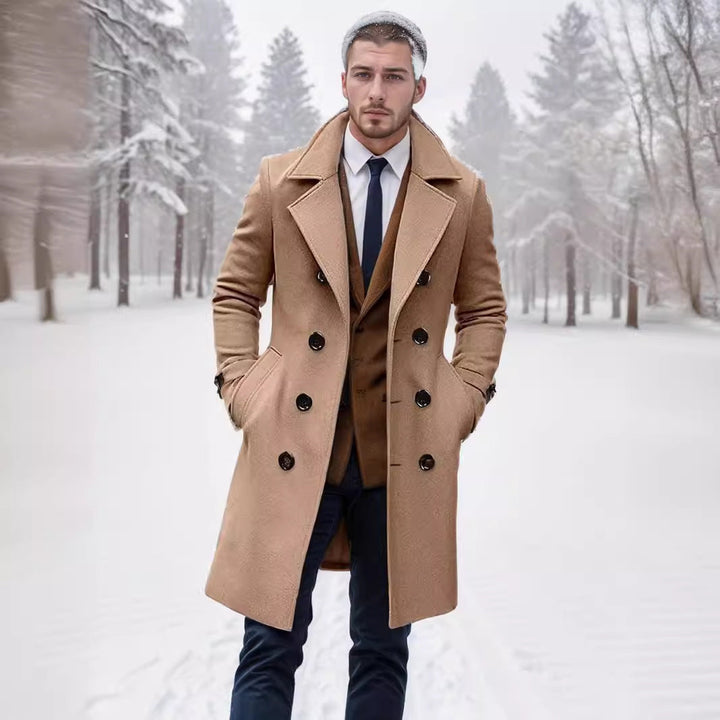 Willem beige trenchcoat in sneeuwlandschap, volledig staand model