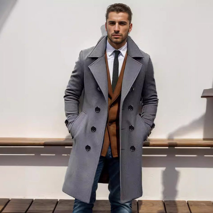 Willem grijze trenchcoat met revers kraag, vooraanzicht tegen muur