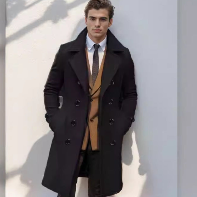 Willem zwarte trenchcoat met revers kraag, vooraanzicht tegen muur